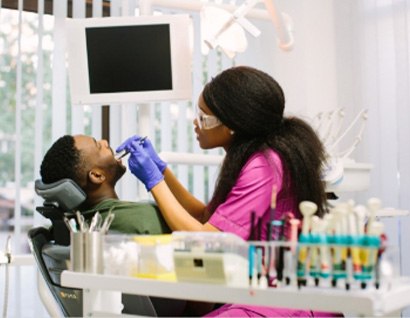 man with dental assistant looking at smile